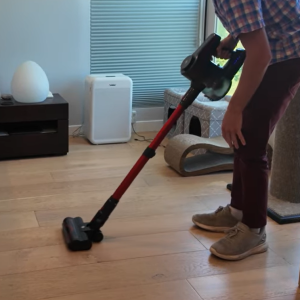A person using cordless vacuum cleaner on floor