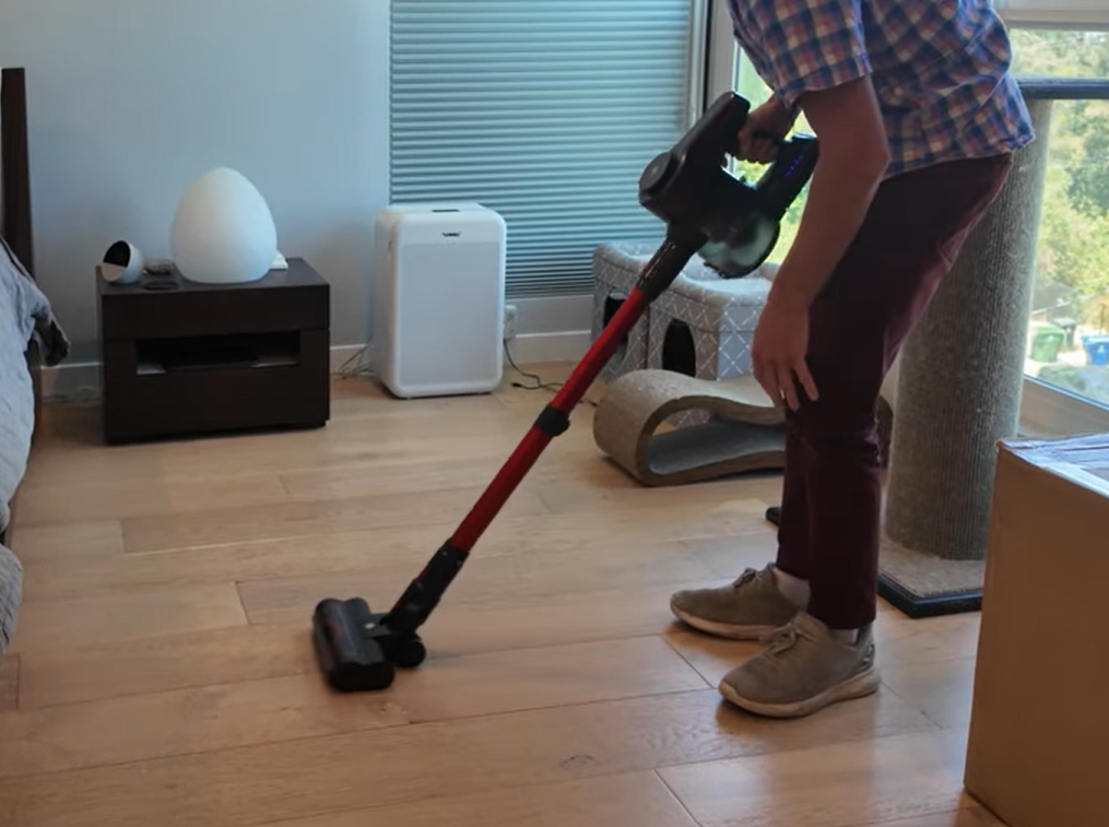 A person using cordless vacuum cleaner on floor